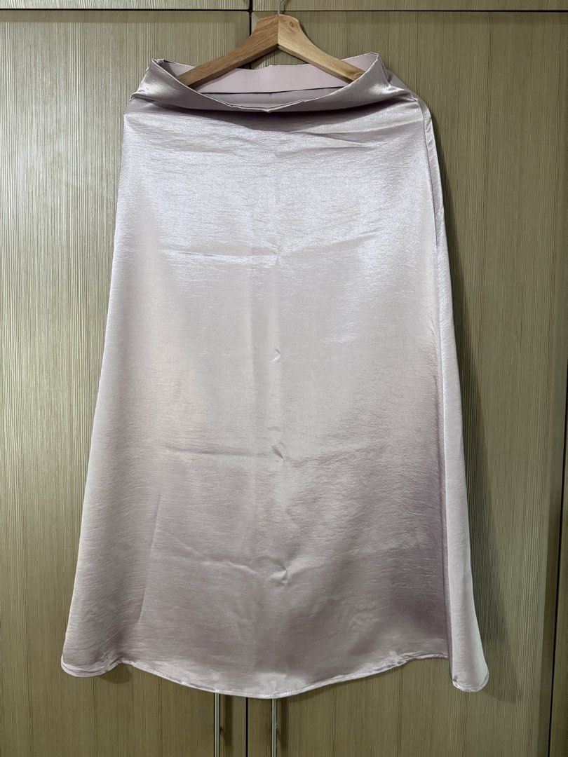 Pink Satin Midi Skirt with Side Slit (Category: Skirts) located in Taguig. Submitted by mengxir20193848 (Listing ID 1468988900, Image 2). Description: - Color: Light pink - Material: Smooth, glossy satin with a lovely drape - Fit: High-waisted with a comfortable elastic waistband - Design: Chic side slit for easy movement - Condition: Clean, no flaws noticed - Styling: Perfect for both casual daytime looks and dressed-up evenings.