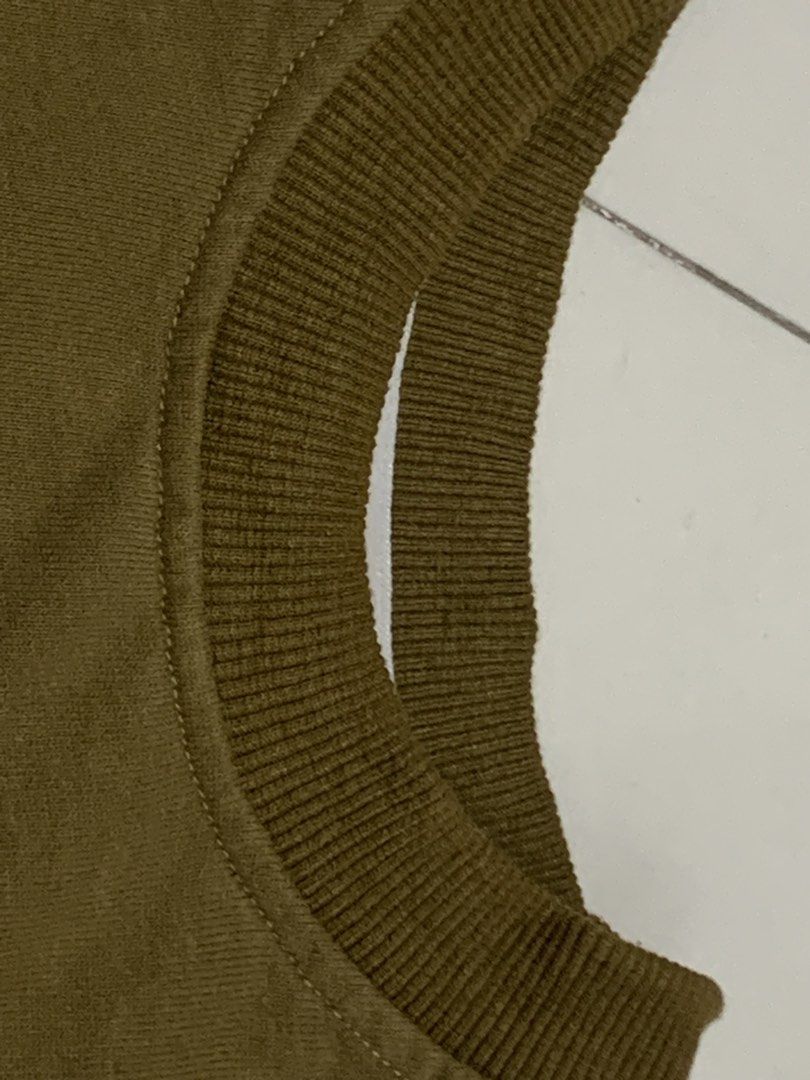 Pleasures Olive Green Crop Top with Graphics (Category: Shirts) located in Manila. Submitted by mixwearclosetclothingstore (Listing ID 1468951529, Image 3). Description: - Brand: Pleasures - Color: Brown with white graphic text - Style: Sleeveless crop top with ribbed round collar - Details: Distressed raw edges at armholes and tie-side slits at the hem - Material: Soft cotton fabric.