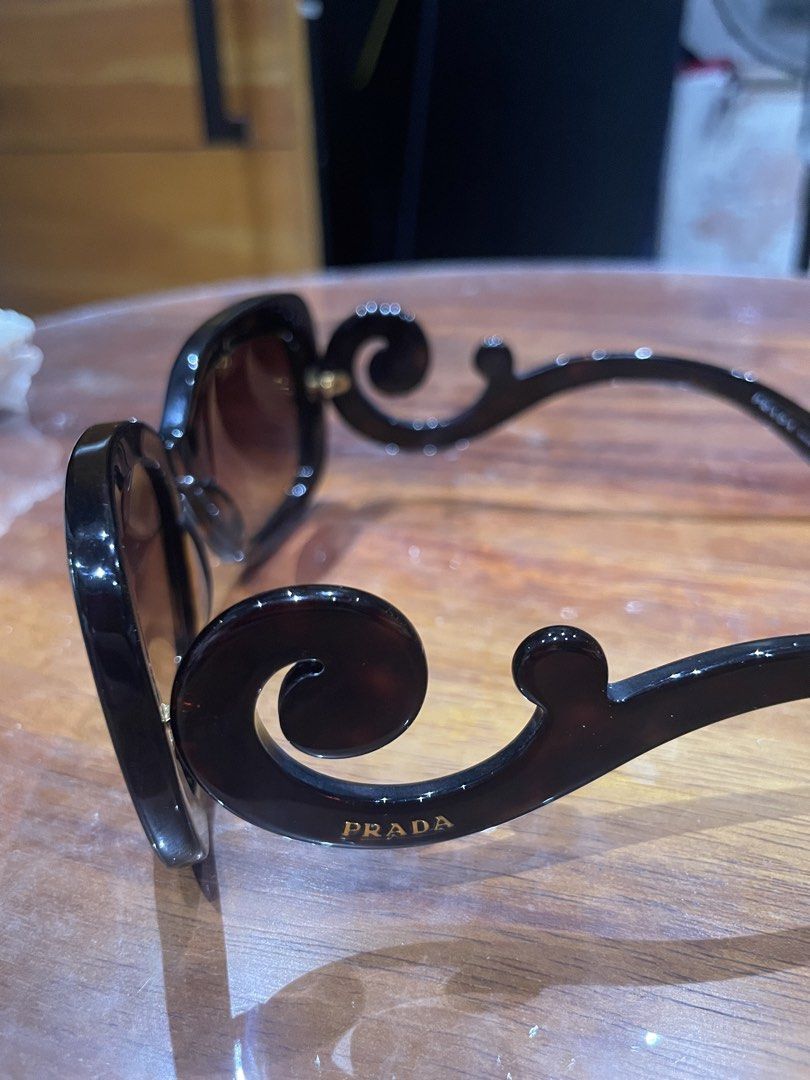 Prada Baroque Tortoise Sunglasses SPR 27Q (Category: Sunglasses & Eyewear) located in Marikina City. Submitted by ffm73 (Listing ID 1469158958, Image 2). Description: - Brand: Prada - Model: Baroque SPR 27Q (Size: 54-20 135 2N) - Frame: Tortoise shell pattern with iconic thick scroll temples and gold Prada lettering - Lenses: Gradient brown - Origin: Made in Italy - Inclusions: Original white Saffiano leather hard case with silver Prada logo - Co