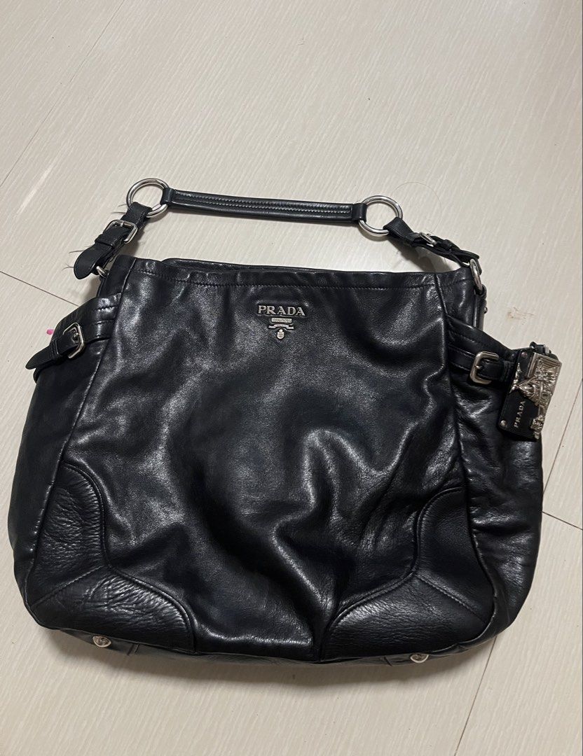 Prada Black Leather Shoulder Bag (Category: Luxury Bags & Wallets) located in Dumangas. Submitted by chiiieeef (Listing ID 1469084176, Image 1). Description: - Authentic black crinkled leather Prada handbag - Stylish silver-tone hardware with top metal logo plaque - Chic decorative side buckle charms - Signature Prada logo fabric interior lining - Interior zippered pocket with authentic leather brand patch - Adjustable double ring shoulder straps