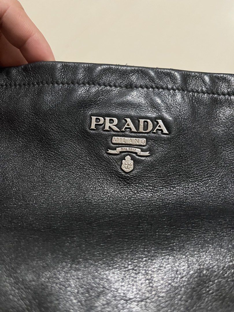 Prada Black Leather Shoulder Bag (Category: Luxury Bags & Wallets) located in Dumangas. Submitted by chiiieeef (Listing ID 1469084176, Image 2). Description: - Authentic black crinkled leather Prada handbag - Stylish silver-tone hardware with top metal logo plaque - Chic decorative side buckle charms - Signature Prada logo fabric interior lining - Interior zippered pocket with authentic leather brand patch - Adjustable double ring shoulder straps