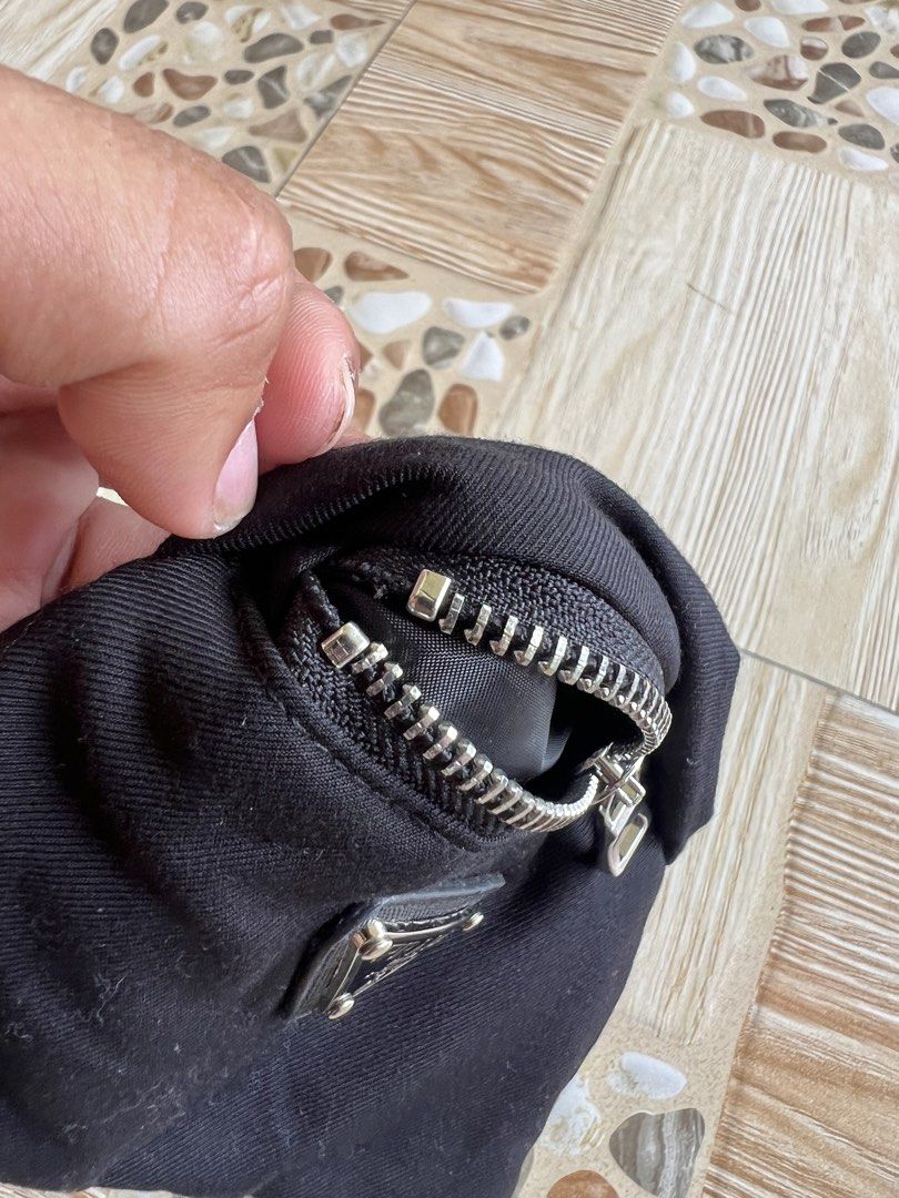 Prada Black Nylon Pouch with Triangle Logo (Category: Luxury Bags & Wallets) located in Iba. Submitted by saploot (Listing ID 1469116444, Image 3). Description: - Authentic Prada black nylon pouch - Iconic enameled metal triangle logo on the front - Smooth and durable riri zipper hardware - Dual strap loops on the back for versatile carrying options - Compact size ideal for coins, cards, keys, or small essentials - Classic, minimalist design suit