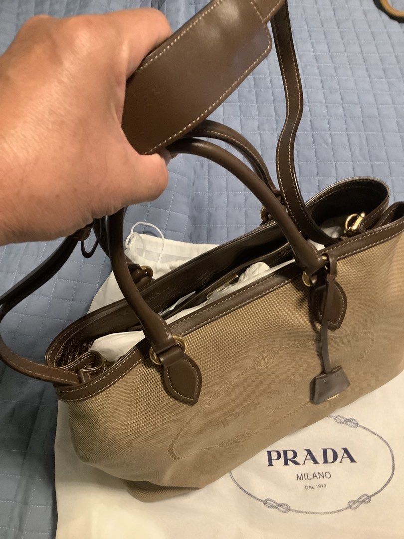PRADA Borsa A Mano Satchel Bag (Category: Luxury Bags & Wallets) located in Taytay. Submitted by eugeneyoung (Listing ID 1469161056, Image 2). Description: Prada Borsa A Mano Logo Jacquard Satchel. In corda Bruciato. Crossbody bag brown leather. Beige canvas with Brown leather Trim. Gold tone hardware. Snap button closure. One interior slip pocket. Good condition. Authentic Prada bag. .