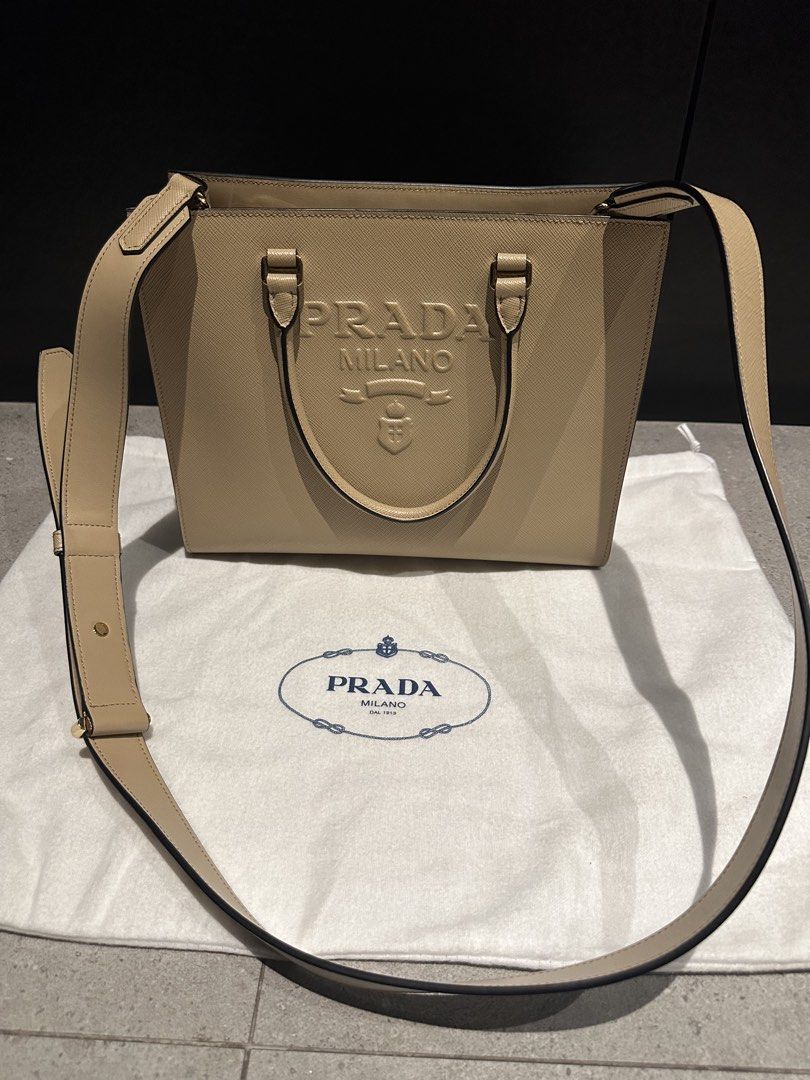 Prada Saffiano Leather Tote Bag Beige (Category: Luxury Bags & Wallets) located in Quezon City. Submitted by nix888 (Listing ID 1468948624, Image 2). Description: Prada tote bag in beige Saffiano leather. Embossed logo on front, dual top handles, adjustable removable shoulder strap. Gold-tone hardware, zip pocket inside, fabric lining. Includes original dust bag and authenticity cards. Price is negotiable. Barely used. No damages. Bought last Feb