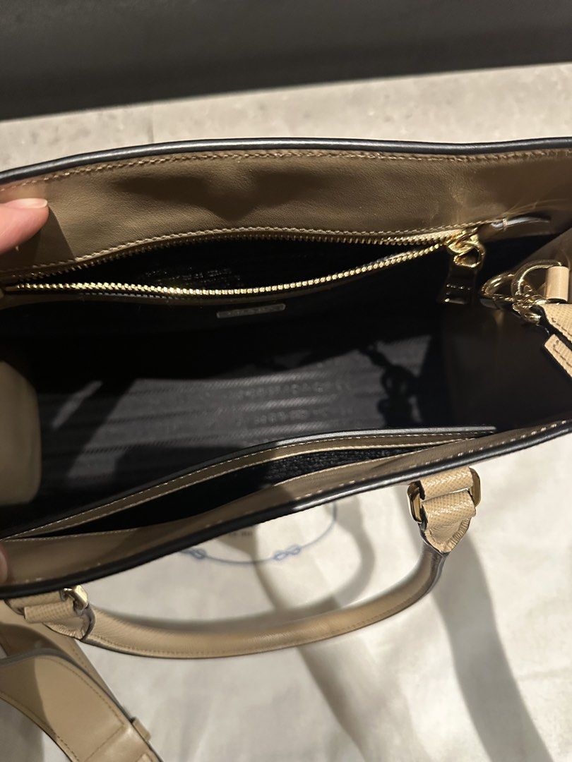 Prada Saffiano Leather Tote Bag Beige (Category: Luxury Bags & Wallets) located in Quezon City. Submitted by nix888 (Listing ID 1468948624, Image 3). Description: Prada tote bag in beige Saffiano leather. Embossed logo on front, dual top handles, adjustable removable shoulder strap. Gold-tone hardware, zip pocket inside, fabric lining. Includes original dust bag and authenticity cards. Price is negotiable. Barely used. No damages. Bought last Feb