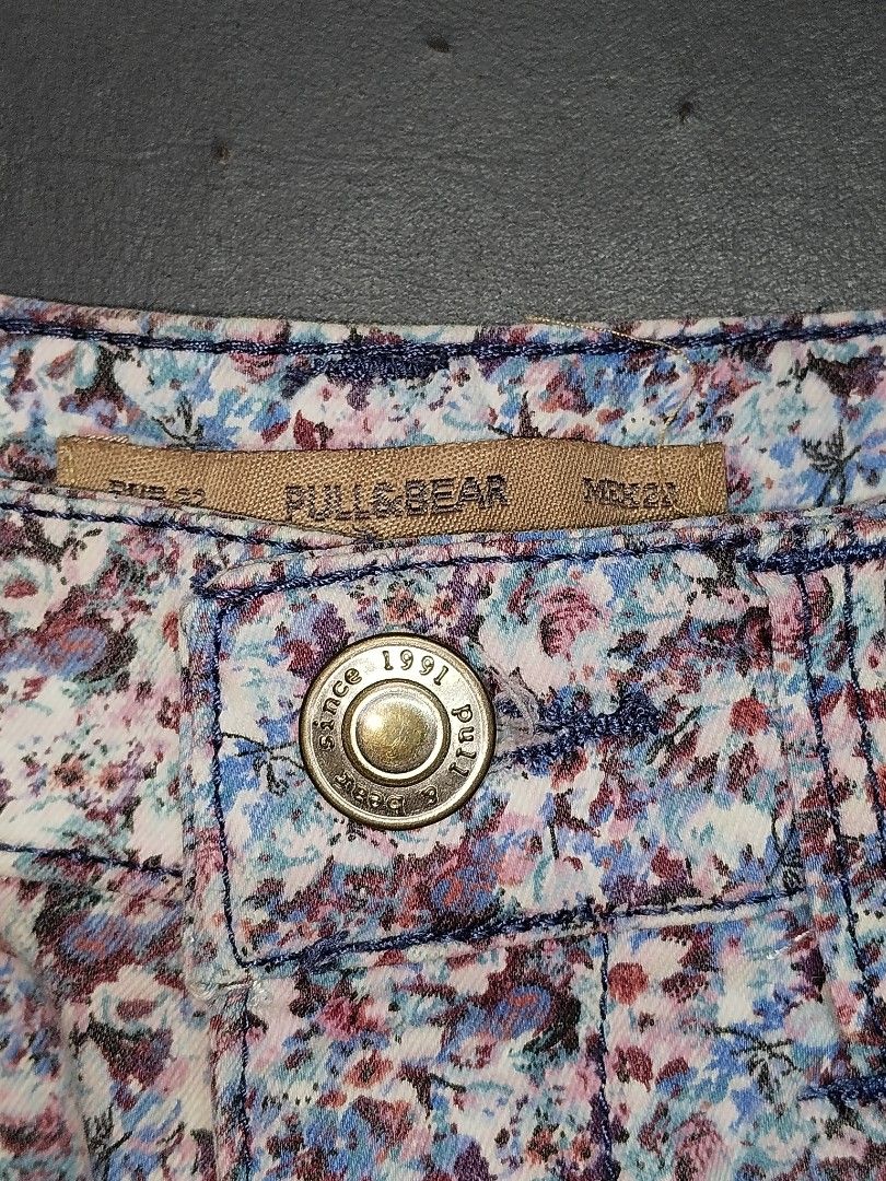 Pull&Bear Floral Print Denim Shorts (Category: Shorts) located in Manila. Submitted by thrift.fairy11 (Listing ID 1468935699, Image 2). Description: - Brand: Pull&Bear - Style: High-waist denim shorts with front button closure and classic 5-pocket design - Pattern: All-over cute floral print in purple, blue, and white tones - Details: Metal branded plaque on the front coin pocket - Size: EUR 32 / MEX 24 - Condition: Great piece for warmer weather