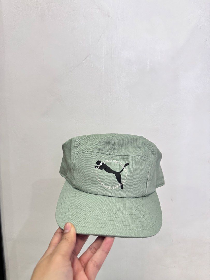 Puma Green Cap Hat (Category: Caps & Hats) located in Tarlac. Submitted by kyasonik (Listing ID 1468962385, Image 1). Description: - Color: Classic Green - Design: Front logo embroidery with Puma text graphic inside a circle - Fit: Adjustable strap at the back for a customized fit - Details: Interior tags with care instructions and Puma branding intact - Condition: Clean fabric throughout, great addition to casual outfits.