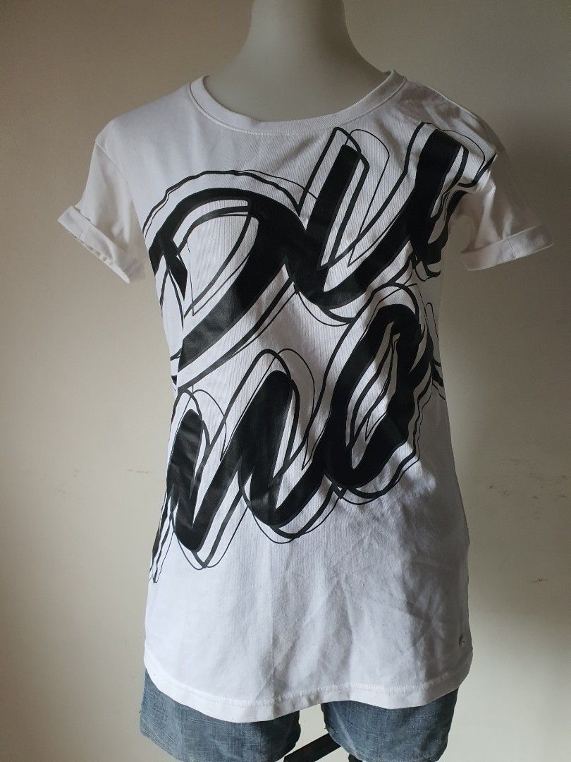 Puma White Black Graphic T-shirt (Category: Shirts) located in Meycauayan. Submitted by shoptoown (Listing ID 1468935900, Image 1). Description: - Brand: Puma - Color: White with large black graphic print on front - Details: Round neckline, short sleeves, small logo tag near hem, and small logo on back collar - Measurements: Approx. 23 inches across (pit-to-pit) and 17 inches in length - Condition: Minor fabric pilling on the white material.