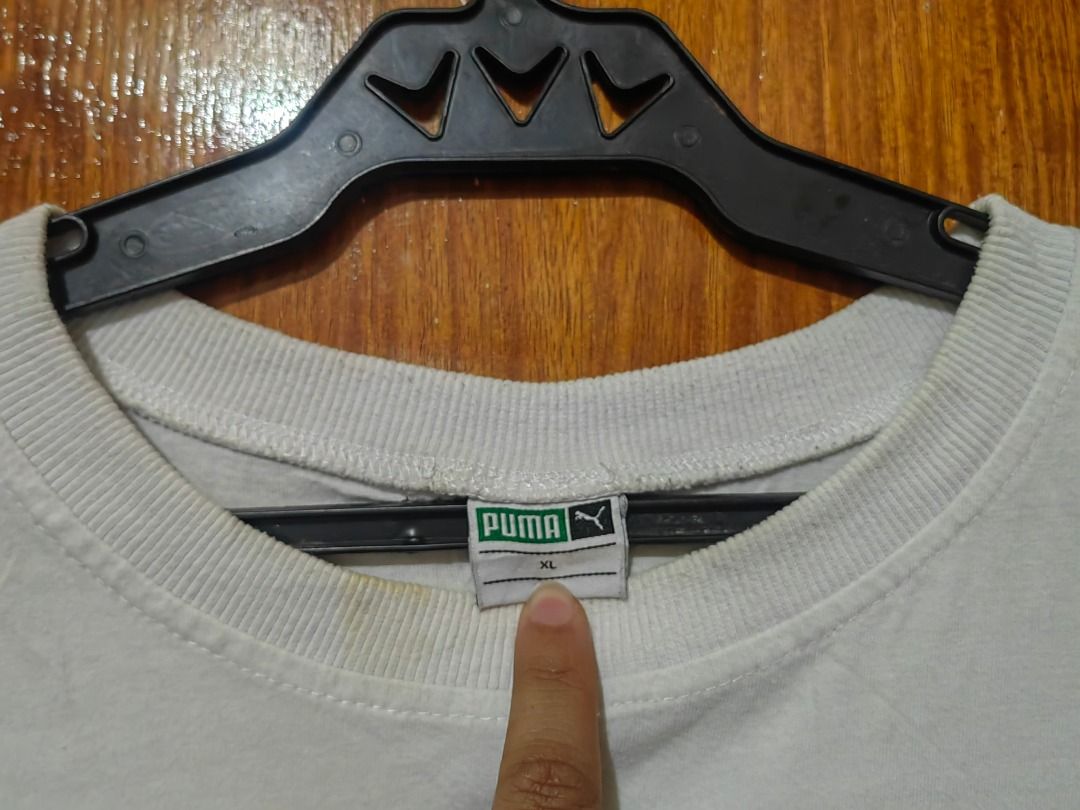 Puma White T-Shirt XL (Category: Shirts) located in Caloocan City. Submitted by carolanglu40603 (Listing ID 1469005825, Image 3). Description: - Brand: Puma - Size: XL - Color: White with green box logo on inner collar - Style: Classic crew neck, short sleeves - Condition: Soft and broken-in fabric, with some yellowish discoloration around the neckline from age and previous wear.
