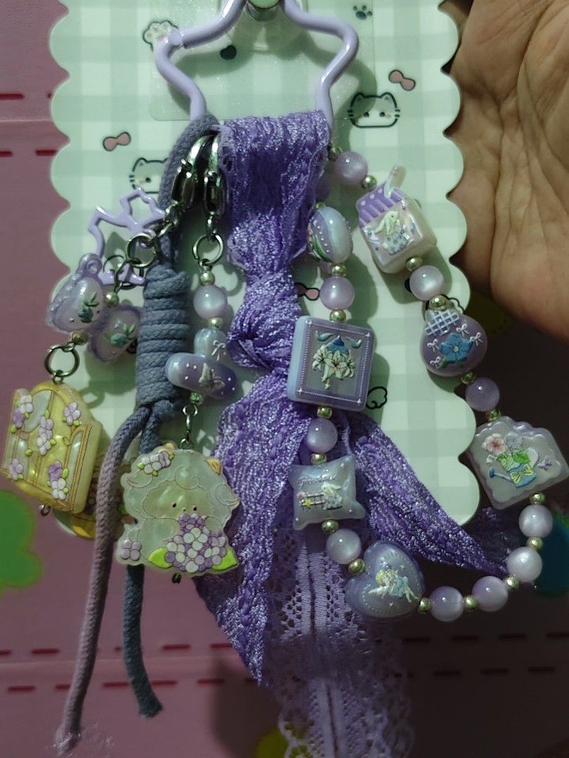 Purple Keychains (Category: Charms) located in Rizal. Submitted by yves1211 (Listing ID 1469085646, Image 1). Description: - Brand new with original backing card - Dreamy purple aesthetic design - Features cute cartoon charms, beads, pastel flowers, and lace ribbon - Versatile clip for bags, keys, or phone cases - Perfect gift or personal accessory.