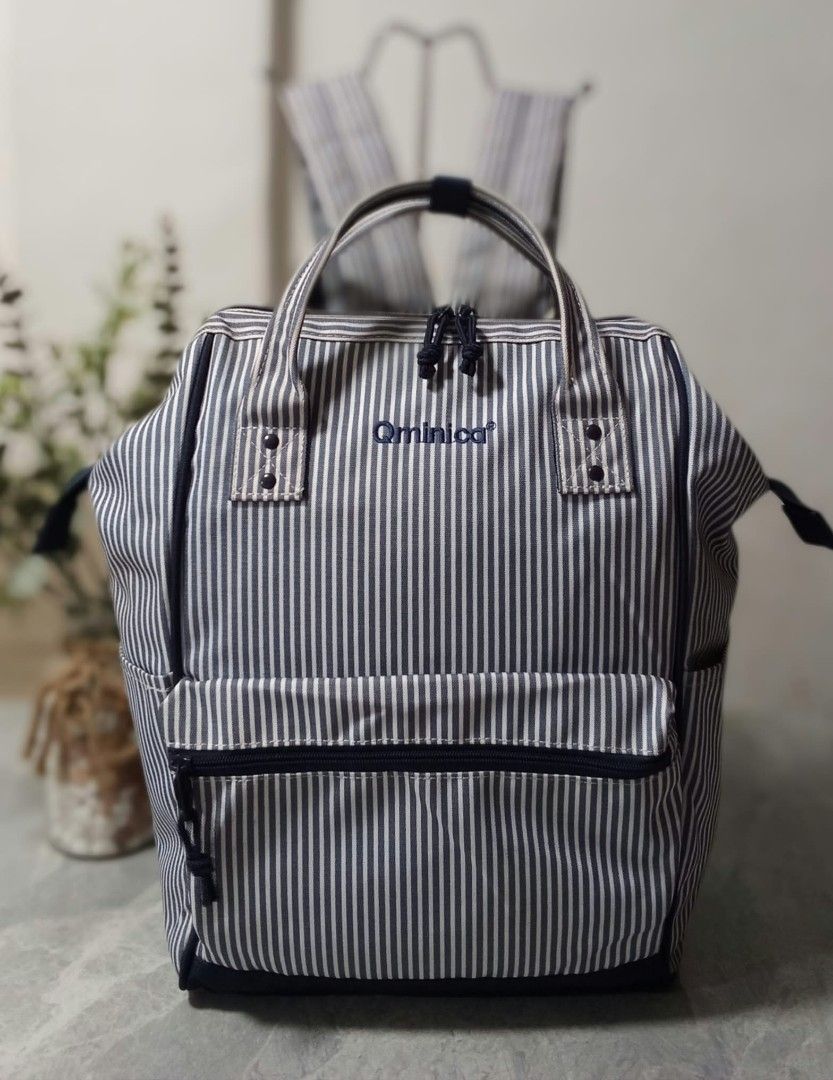 Qminica Navy and White Striped Backpack (Category: Backpacks) located in Manila. Submitted by cosmiccloud-9236 (Listing ID 1468964614, Image 1). Description: Navy and white vertical striped canvas backpack with the Qminica brand embroidered on the front. Double top handles and a front zipper pocket. Back straps are padded with black mesh material, adjustable with plastic buckles. Includes an extra security zip pocket on the back panel..