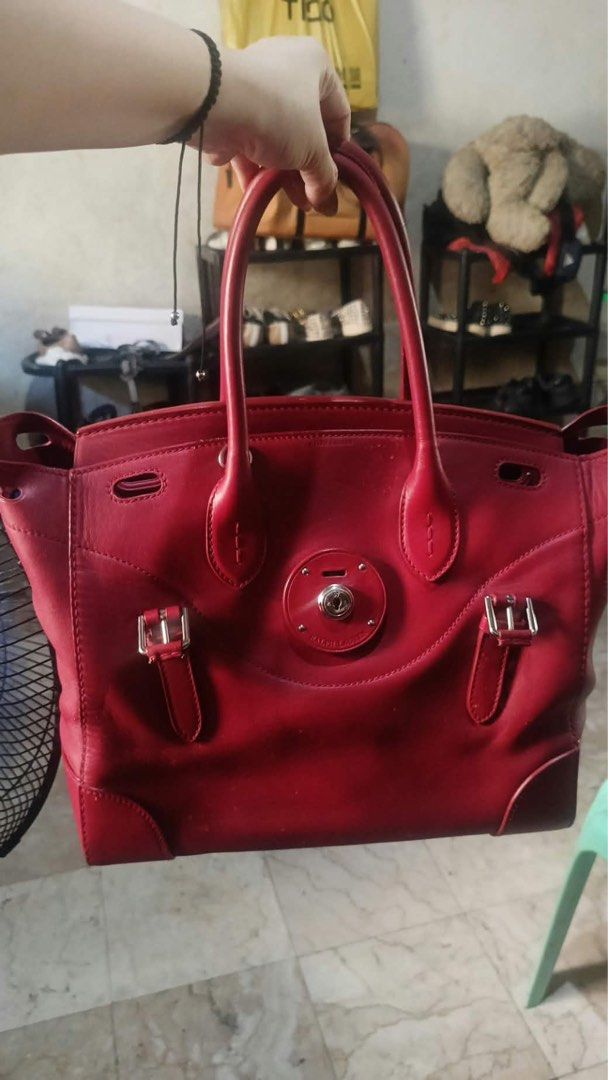 RALPH LAUREN TICKY BAG (PROJECT) (Category: Luxury Bags & Wallets) located in Masbate. Submitted by thon0806 (Listing ID 1469027479, Image 1). Description: - Color: Rich red - Material: Leather - Features: Dual top handles, silver hardware, front clasp closure, decorative strap accents, and a roomy interior - Condition: Noticeable flaking and surface peeling on the front exterior (shown in close-up); clean hardware and sturdy handles otherwise - 