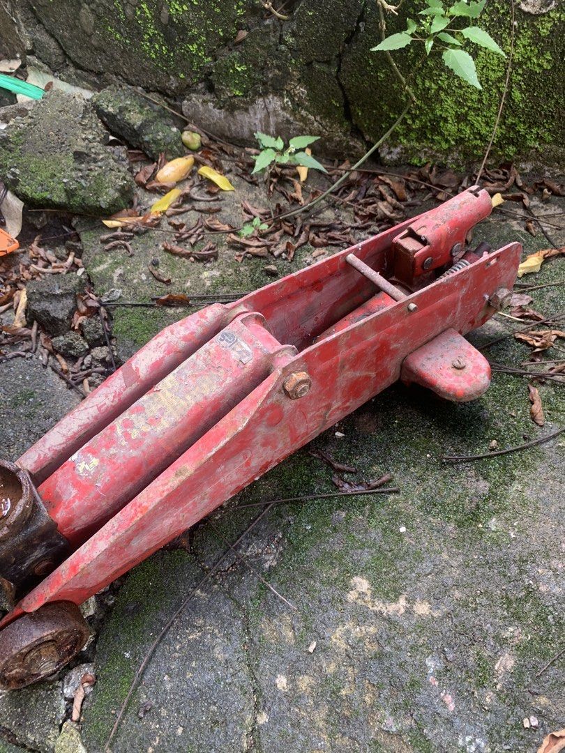 Red Hydraulic Floor Jack (Category: Construction Tools & Equipment) located in Quezon City. Submitted by sojisup (Listing ID 1468985278, Image 3). Description: - Heavy-duty metal red hydraulic floor jack - Wheels still turn smoothly - Significant rust and paint wear due to outdoor storage - Hydraulic mechanism needs testing or servicing - Ideal practical tool for garage work or restoration projects.