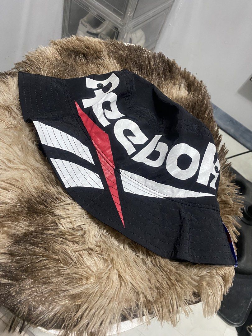 Reebok bucket hat biglogo (Category: Caps & Hats) located in Manila. Submitted by japhetcond32104 (Listing ID 1469110775, Image 1). Description: - Brand: Reebok - Item: Bucket Hat with Big Logo Design - Color: Black with white and red accents - Size: OSFX (57-60 cm) - Material: 100% Nylon (Outer), 100% Polyester (Inner lining) - Meetup location: Ayala Malls Circuit, Makati.