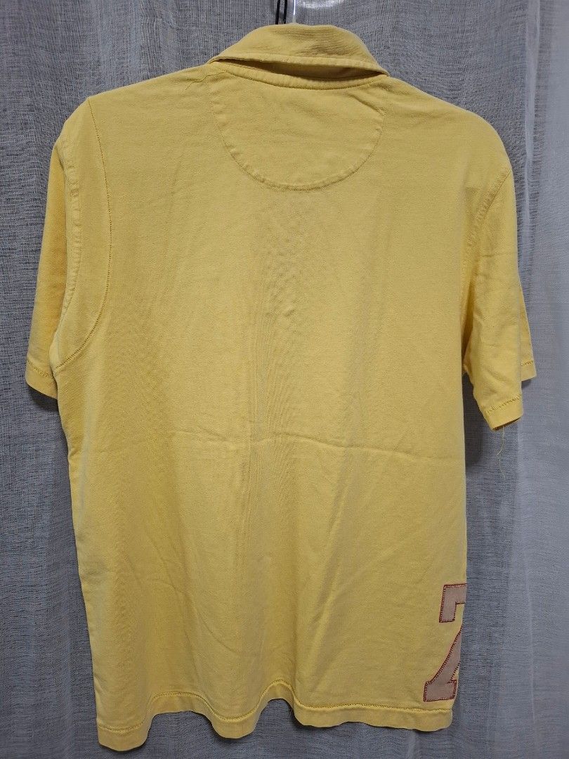 Reebok Yellow Polo Shirt Size M (Category: Tshirts & Polo Shirts ) located in Manila. Submitted by jazil.ladyliz (Listing ID 1469071822, Image 3). Description: - Brand: Reebok - Size: Medium (M) - Color: Vibrant Yellow - Material: 100% Cotton (Made in China) - Design: Classic collar, 2-button placket, stylish vertical pin stripes - Details: Embroidered Reebok logo on chest, large number 79 graphic patch near bottom hem - Condition: Excellent, rea
