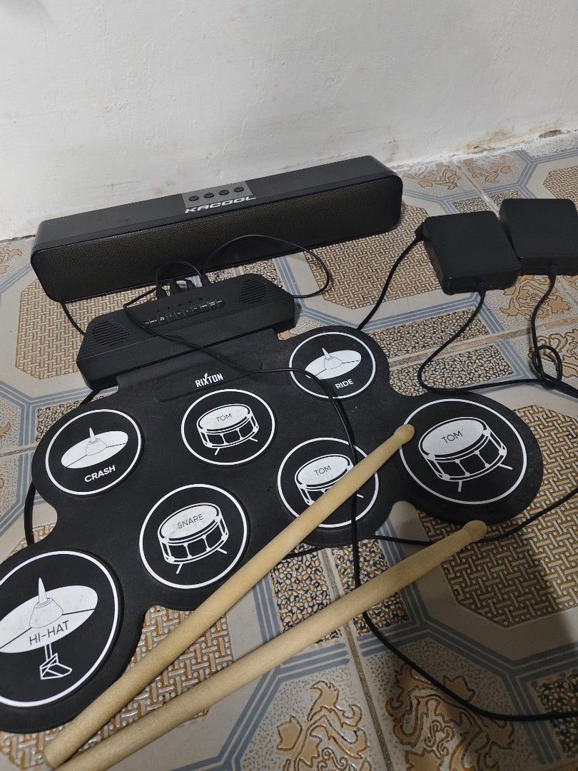 Rixton Portable Electronic Drum Pad Set With Speaker And Pedals (Category: Musical Instruments) located in General Mariano Alvarez. Submitted by findsandmoreph (Listing ID 1469031880, Image 1). Description: - Brand: Rixton Portable Electronic Drum Pad - Complete bundle includes: Roll-up silicone pad, Kacool black soundbar speaker, 2 foot pedals (bass & -hat), and wooden drum sticks - Features multiple percussion zones: snare, -hat, crash, ride, a