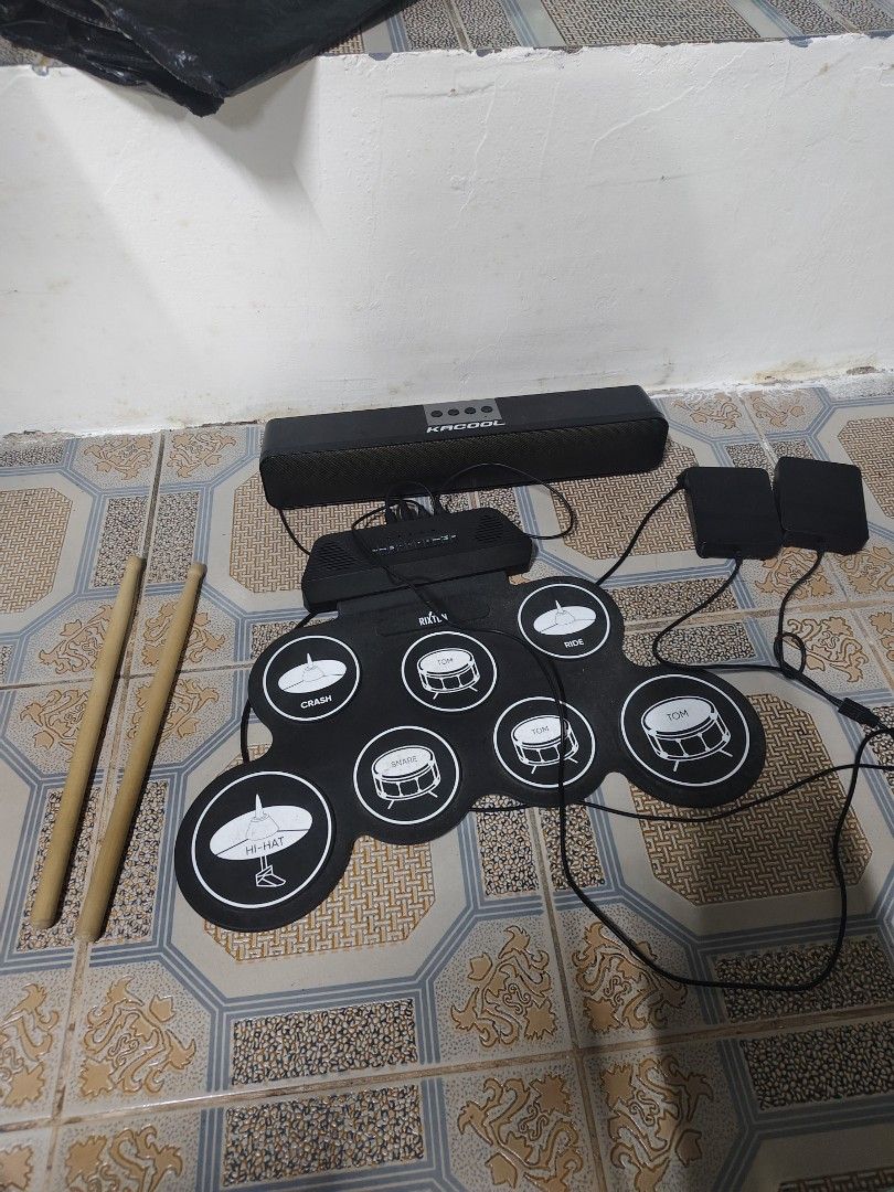 Rixton Portable Electronic Drum Pad Set With Speaker And Pedals (Category: Musical Instruments) located in General Mariano Alvarez. Submitted by findsandmoreph (Listing ID 1469031880, Image 3). Description: - Brand: Rixton Portable Electronic Drum Pad - Complete bundle includes: Roll-up silicone pad, Kacool black soundbar speaker, 2 foot pedals (bass & -hat), and wooden drum sticks - Features multiple percussion zones: snare, -hat, crash, ride, a