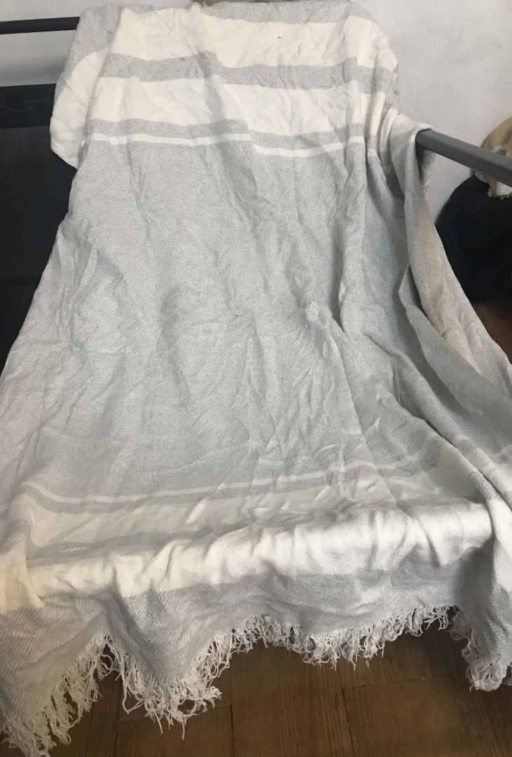 Rosa Home Grey And White Striped Throw Blanket (Category: Bedding & Towels) located in Imus. Submitted by stop_shop7 (Listing ID 1468958845, Image 3). Description: - Brand: Rosa Home - Design: Grey and white stripes with a woven herringbone texture and fringe ends - Material: Soft and comfortable fabric - Use: Perfect for draping over a sofa, couch, or bed - Condition: Good, with minor fraying on one section of the weave near the edge.