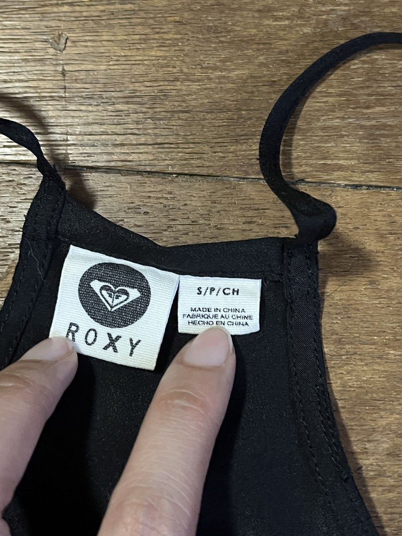 Roxy Black Camisole Tank Top Size S (Category: Sleeveless) located in Manila. Submitted by carmiscloset (Listing ID 1469005583, Image 2). Description: - Brand: Roxy - Size: S would fit medium - Color: Black - Style: Racerback camisole with V-neck and curved hem - Detail: Small metal Roxy logo tag near hem - Material: Lightweight fabric, ideal for warm weather.