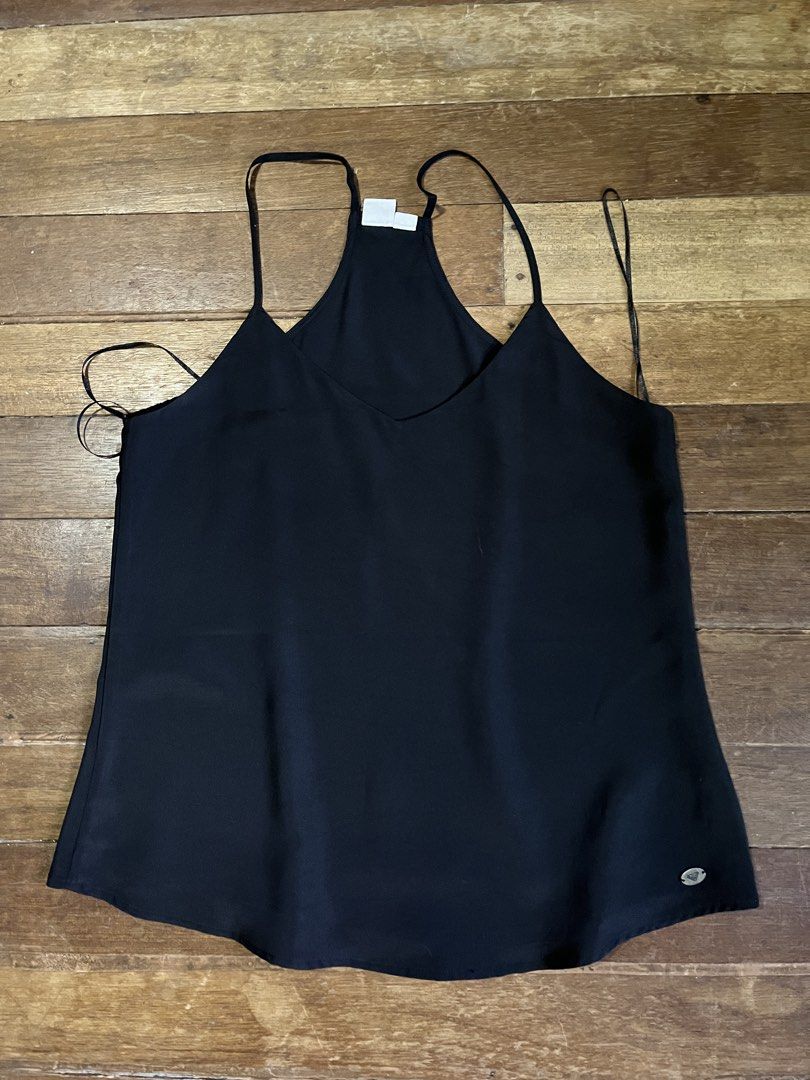Roxy Black Camisole Tank Top Size S (Category: Sleeveless) located in Manila. Submitted by carmiscloset (Listing ID 1469005583, Image 1). Description: - Brand: Roxy - Size: S would fit medium - Color: Black - Style: Racerback camisole with V-neck and curved hem - Detail: Small metal Roxy logo tag near hem - Material: Lightweight fabric, ideal for warm weather.
