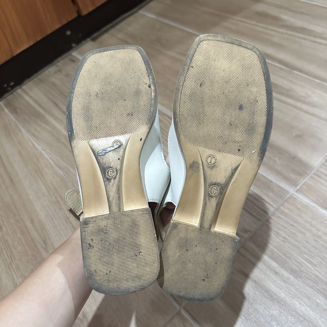 Rusty Lopez White Strappy Sandals Size 6 (Category: Flats & Sandals) located in Pasig City. Submitted by nina.declutter (Listing ID 1469033614, Image 3). Description: - Brand: Rusty Lopez - Color: White with light beige footbed - Size: 6 - Design: Square toe, multiple straps with gold-tone buckle details - Closure: Adjustable slingback buckle - Condition: Uppers are in solid condition, with moderate wear on the bottom soles.