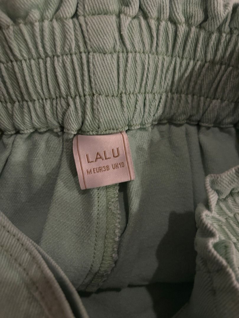 Sage Green High-Waisted Wrap Skort (Category: Skirts) located in Muntinlupa City. Submitted by wisemountain-8175 (Listing ID 1469039766, Image 3). Description: - Singaporean Brand - Size: M (EUR 38, UK 10) - Color: Sage green (perfect for summer) - Material: Lightweight cotton-blend fabric - Design: High waist, gathered elasticated band, and decorative front buttons - RFS: too small.