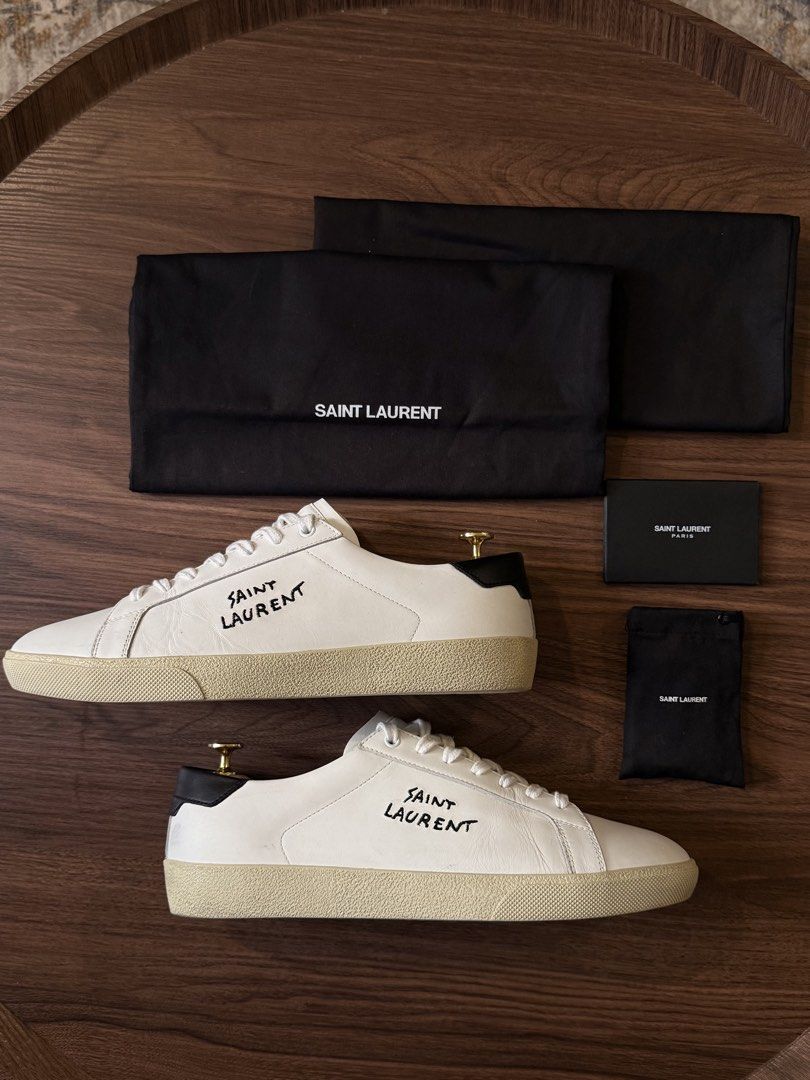 Saint Laurent SL/06 Sneakers (Category: Sneakers & Footwear) located in Manila. Submitted by david_john1 (Listing ID 1468959481, Image 2). Description: - Authentic Saint Laurent white leather sneakers with black heel tabs - Hand-stitched logo lettering on the sides - Complete set: includes original black shoebox, 2 branded dust bags, extra white laces, and documentation cards - Condition: 9/10 Clean uppers and pristine outsoles, carefully maintai