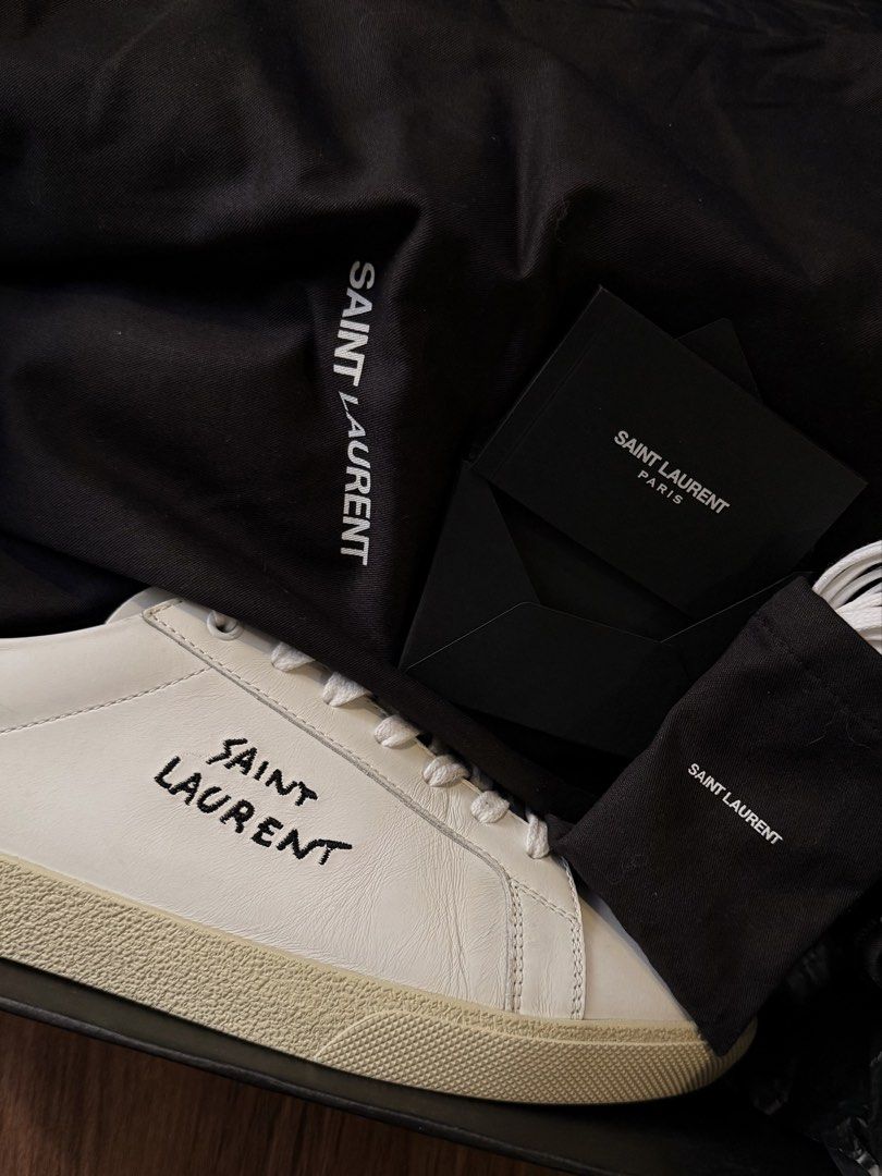 Saint Laurent SL/06 Sneakers (Category: Sneakers & Footwear) located in Manila. Submitted by david_john1 (Listing ID 1468959481, Image 3). Description: - Authentic Saint Laurent white leather sneakers with black heel tabs - Hand-stitched logo lettering on the sides - Complete set: includes original black shoebox, 2 branded dust bags, extra white laces, and documentation cards - Condition: 9/10 Clean uppers and pristine outsoles, carefully maintai