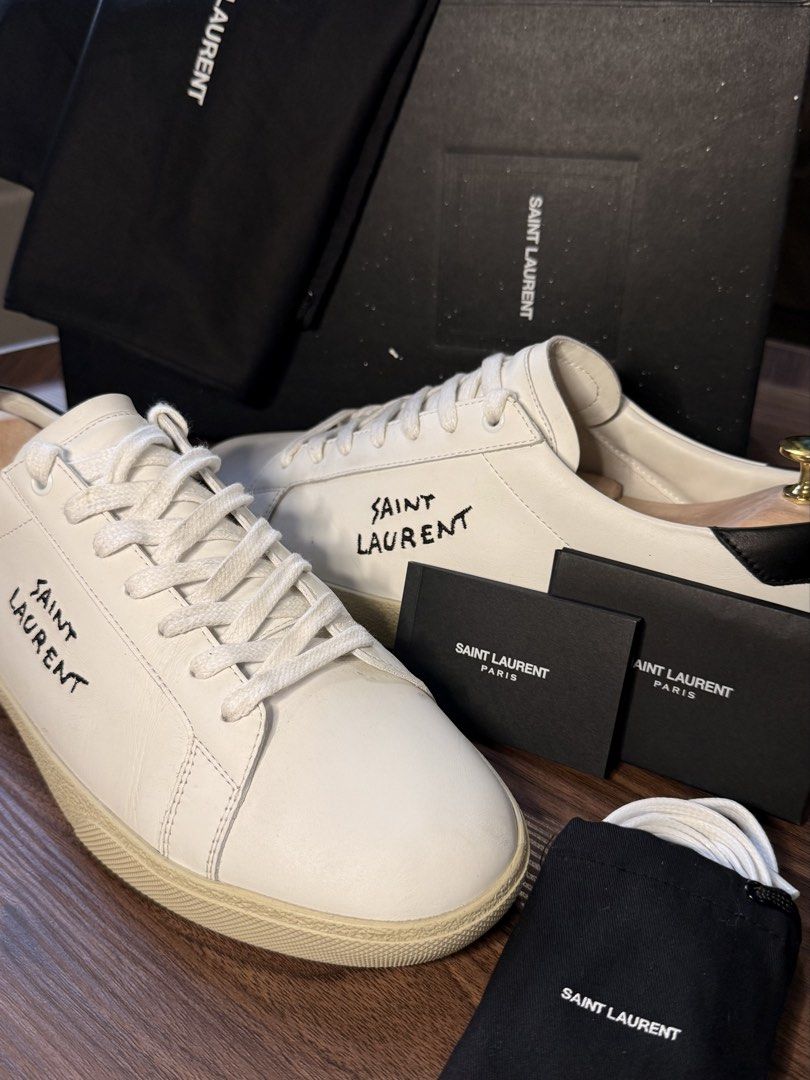 Saint Laurent SL/06 Sneakers (Category: Sneakers & Footwear) located in Manila. Submitted by david_john1 (Listing ID 1468959481, Image 1). Description: - Authentic Saint Laurent white leather sneakers with black heel tabs - Hand-stitched logo lettering on the sides - Complete set: includes original black shoebox, 2 branded dust bags, extra white laces, and documentation cards - Condition: 9/10 Clean uppers and pristine outsoles, carefully maintai