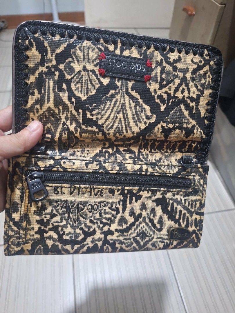 Sakroots Black and Gold Pattern Wallet (Category: Wallets & Card holders) located in Dasmarinas. Submitted by jazvielle (Listing ID 1469088197, Image 2). Description: - Brand: Sakroots - Design: Black and yellow patterned fabric with chic black whipstitch trim - Exterior: Convenient zip pockets on the outside and back - Interior: Multiple card slots, clear ID window, and spacious compartments for cash or a smartphone - Condition: Clean interior, 