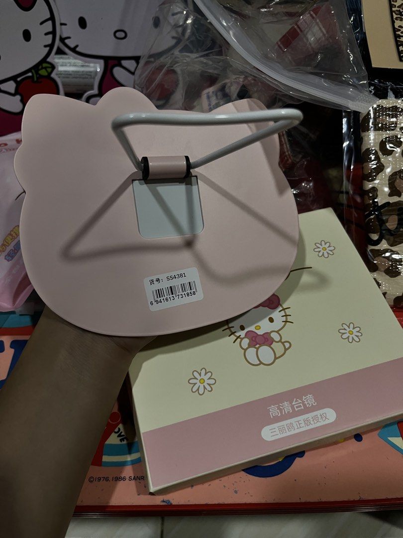 Sanrio Hello Kitty Pink Desktop Mirror with Stand (Category: Mirrors) located in Manila. Submitted by janetecson05 (Listing ID 1468977466, Image 1). Description: - Authentic Sanrio Kitty shaped desktop mirror - Features a sturdy white foldable stand for easy tabletop setup - Comes with the original floral graphics box - Official Sanrio licensed merchandise - Perfect vanity accessory and gift for Kitty fans.