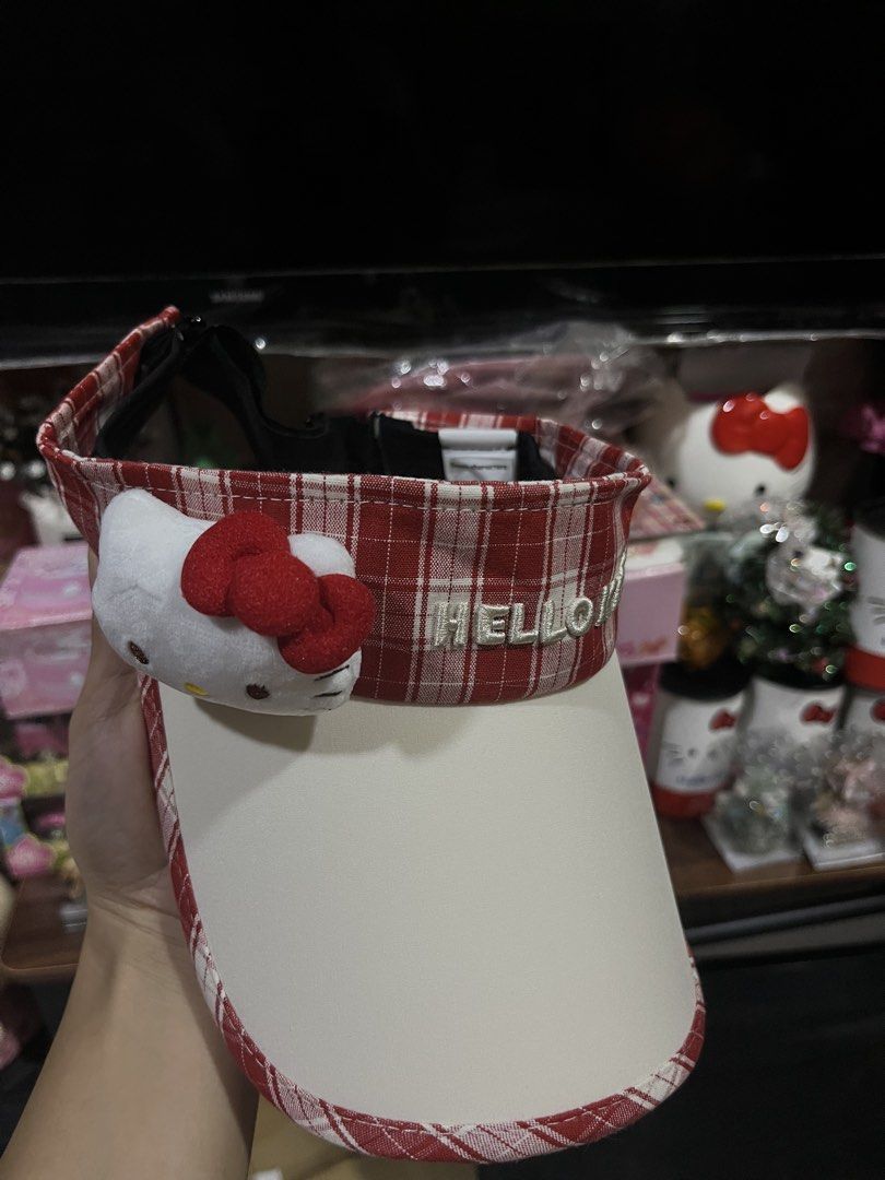 Sanrio Hello Kitty Red Plaid Sun Visor Hat (Category: Hats & Beanies) located in Manila. Submitted by janetecson05 (Listing ID 1468977785, Image 3). Description: - Design: Red and white plaid sun visor with Kitty embroidered branding - Feature: Adorable attached plush character face on the side - Fit: Adjustable black strap at the back for a custom fit - Authenticity: Brand new with Sanrio characters paper tag attached.