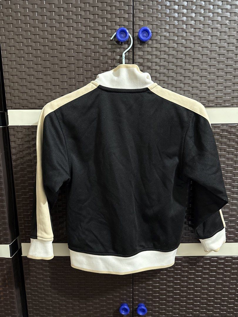 Sean John black track jacket with patches (Category: Coats, Jackets and Outerwear) located in Manila. Submitted by vastwind-676c (Listing ID 1468955061, Image 2). Description: - Brand: Sean John - Style: Classic sportswear track jacket - Color: Black with cream and white accents - Features: Full zip closure, high collar, two front pockets, and white mesh interior lining - Branding: Embroidered Sean John lettering and colorful crest patch on the c