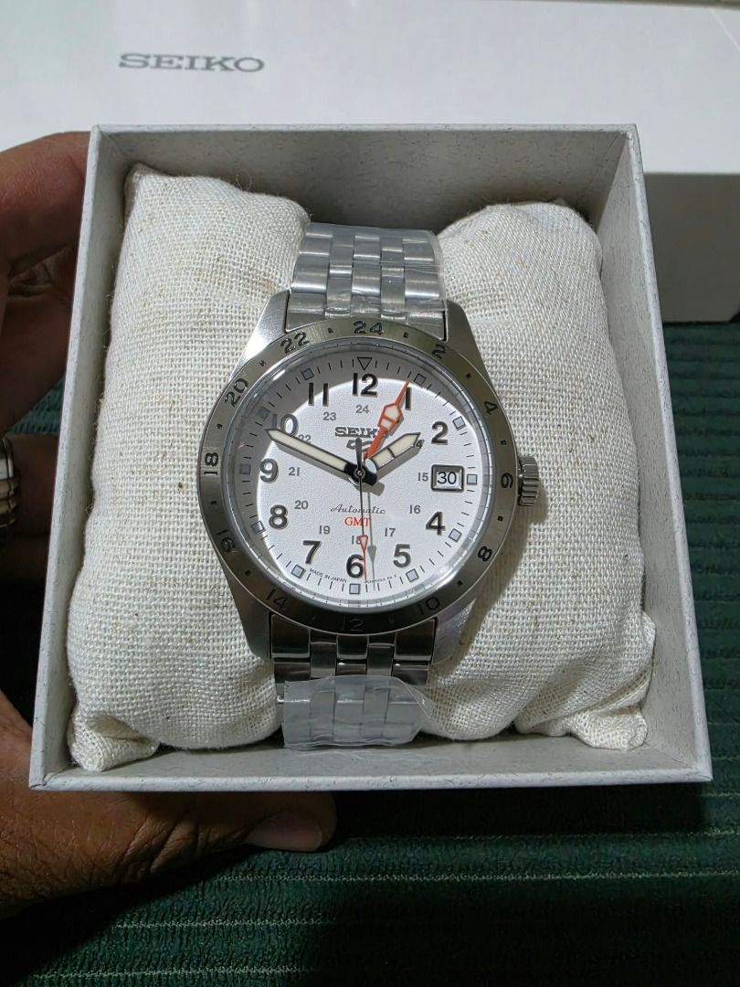 Seiko SBSC009 GMT White Dial Watch (Category: Men's Watches) located in Caloocan City. Submitted by freeturtle.a5f464 (Listing ID 1468964571, Image 3). Description: - Brand: Seiko SBSC009 Automatic GMT Watch - Dial: White dial with Arabic numerals, date window at 3 o'clock, and distinctive orange GMT hand with inner 24-hour scale - Bracelet: Stainless steel bracelet (still wrapped in original protective plastic) - Movement: Reliable mechanical au