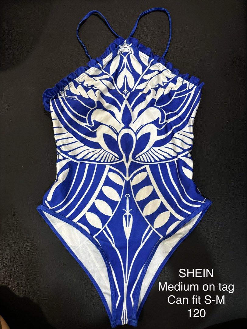 SHEIN Blue White Pattern One Piece Swimsuit Medium (Category: Bikinis & Swimsuits) located in Valenzuela. Submitted by cleighr (Listing ID 1469099120, Image 1). Description: - Brand: SHEIN - Style: Blue and white one-piece swimsuit with halter neck and back strap details - Design: Ruffled trim top edge with a bold graphic print on the front - Size: Medium on tag (fits Small to Medium frames) - Condition: Clean and ready to wear.