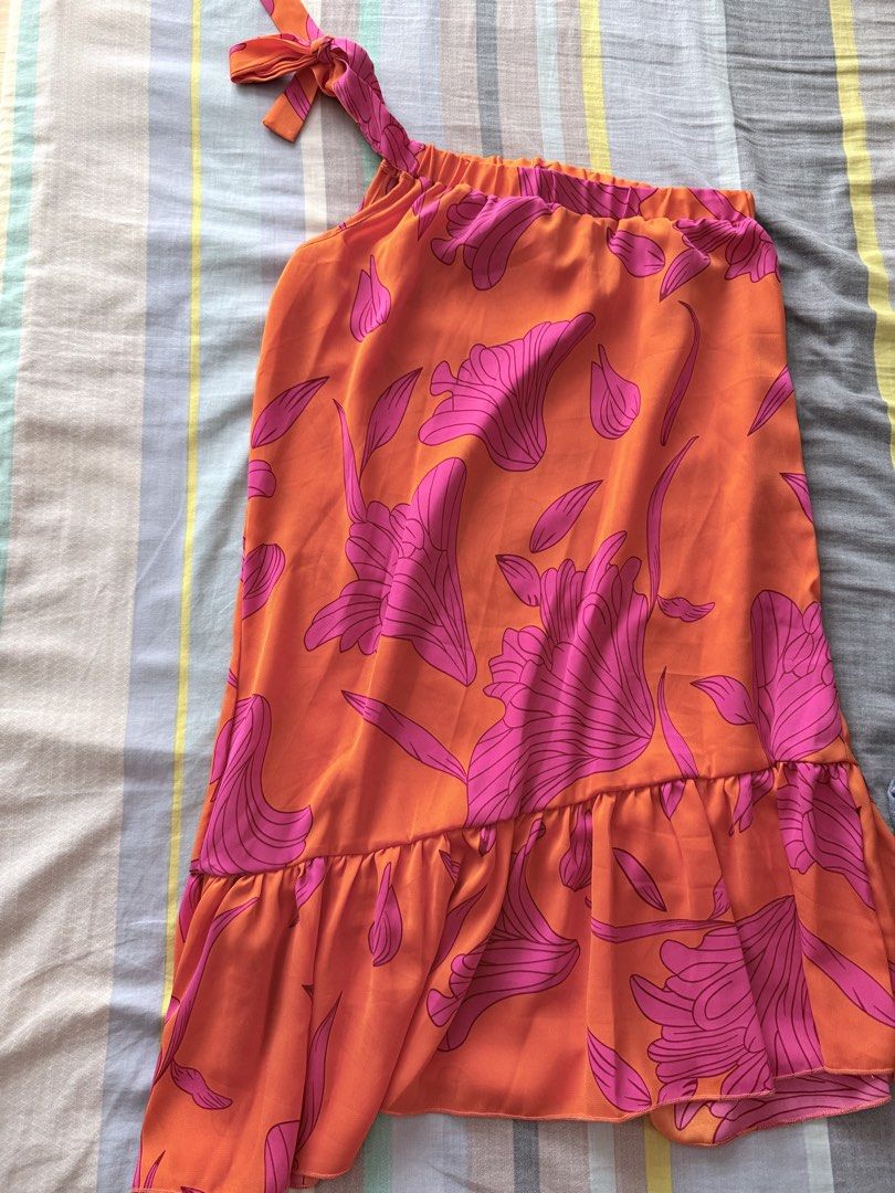 SHEIN Floral One-Shoulder Dress (Category: Dresses) located in Paranaque City. Submitted by roanclauds (Listing ID 1468955839, Image 2). Description: - Brand: SHEIN - Size: S (EUR 36, US 4) - Color/Pattern: Bright orange with all-over pink floral print - Style: One-shoulder neckline with tie strap detail and ruffle hem - Fit: Stretchy elastic band around the top for a secure fit - Fabric: Light and breathable, ideal for warm weather and sunny day