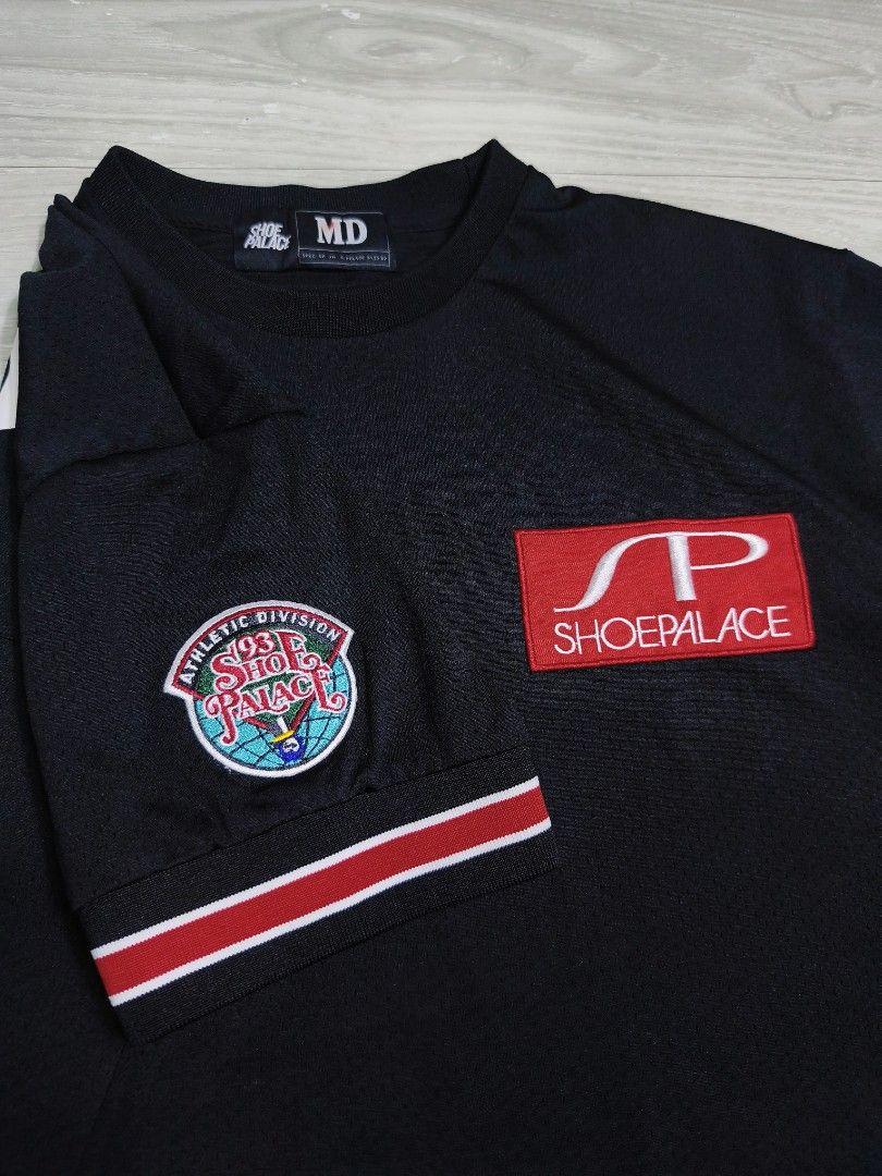 Shoe Palace Athletic Division Jersey (Category: Tshirts & Polo Shirts ) located in Paranaque City. Submitted by pickersform (Listing ID 1469023083, Image 2). Description: - Shoe Palace Athletic Division Jersey - Size: Medium-Large dimes 23x29 - Material: Breathable mesh-like fabric - Design details: Large SP logo patch on left chest, embroidered athletic division patch on right sleeve, and large SP graphic on the back.