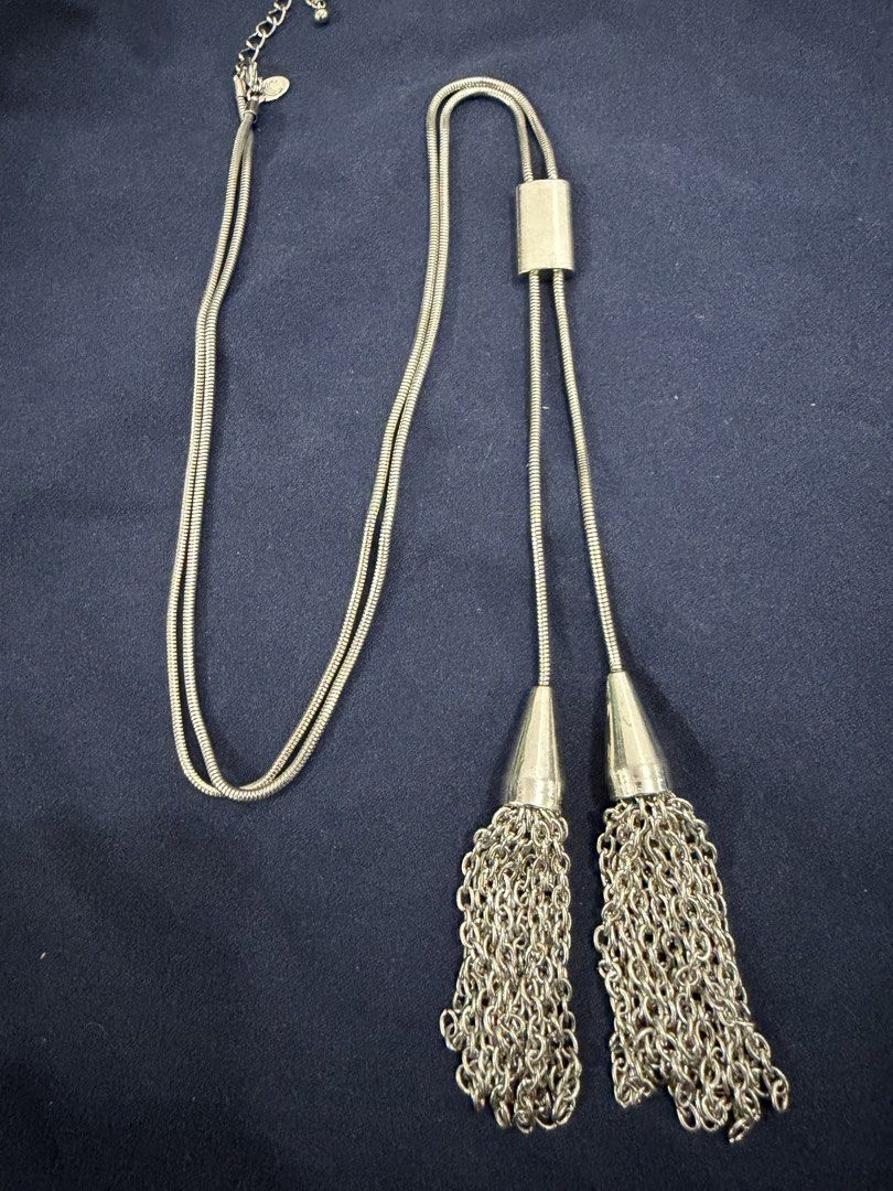 Silver Tone Long Chain Necklace with Tassels (Category: Necklaces) located in Makati City. Submitted by petite_preloved2 (Listing ID 1469063477, Image 1). Description: - Brand- Charming Charlie - Style: Silver-tone long necklace with snake chains - Feature: Double tassel drops with stylish cone caps - Fit: Adjustable chain closure for a customized length - Detail: Includes a cute small logo charm near the clasp - Condition: Clean metal finish thr