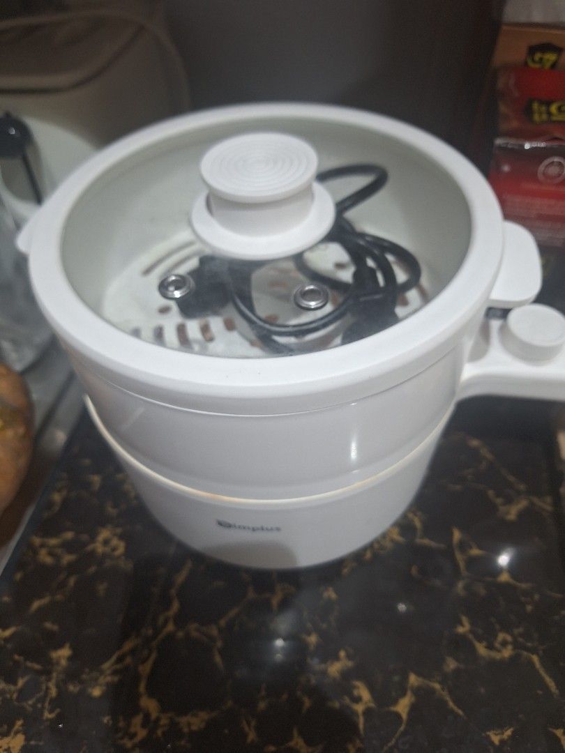 Simplus Electric Cooker Hot Pot With Steamer (Category: Cookers) located in Manila. Submitted by loydamariano (Listing ID 1468937318, Image 2). Description: - Brand: Simplus Electric Cooker - Color/Design: Clean white finish with a convenient long handle - Inclusions: Comes with a steamer tray and glass lid - Features: Built-in cord storage, great for quick meals, dorms, and small kitchens - Condition: Interior shows minor wear marks from previou