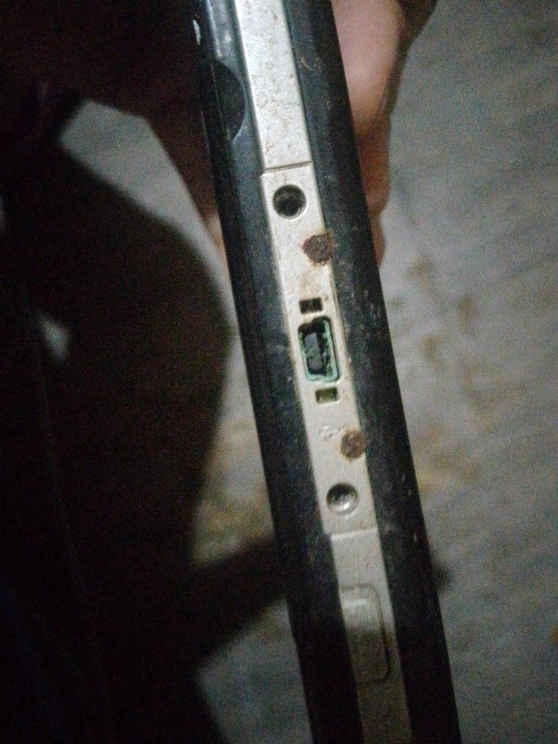 Sony PSP Handheld Console (Category: PlayStation) located in Quezon City. Submitted by mahiwagangkamote (Listing ID 1469023396, Image 3). Description: - Item: Black Sony portable gaming console - Condition: Heavy wear, dirt accumulation, and rust near the charging port - Screen: Numerous scratches and dust present - Battery: Cover is missing, battery is exposed - Purpose: Selling strictly as-is for spare parts or a restoration project - Note: Req