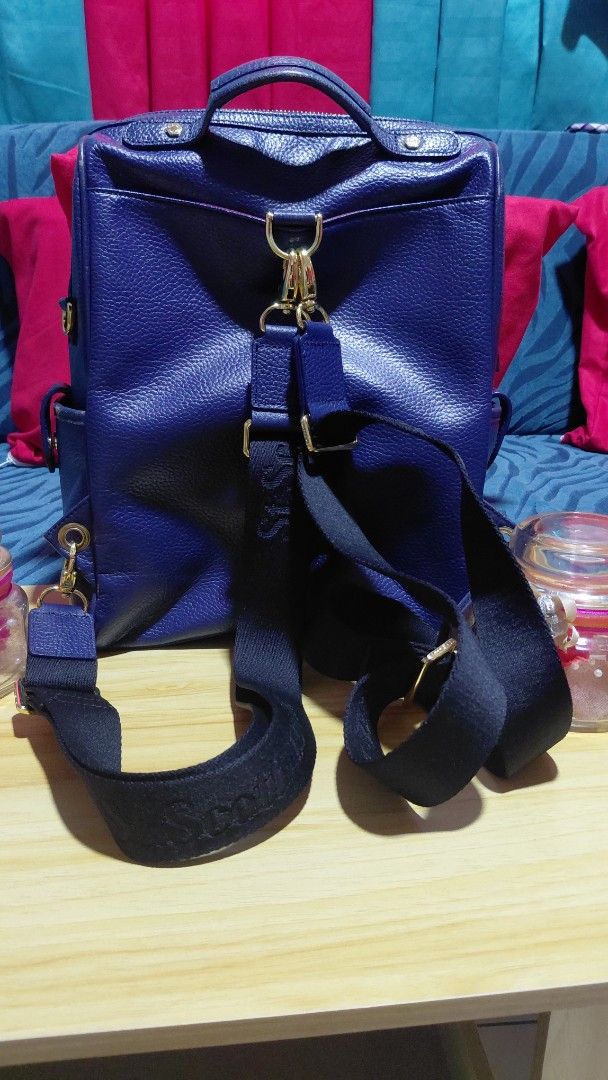 St. Scott London Blue Leather Backpack (Category: Backpacks) located in Davao. Submitted by floresjayne0124 (Listing ID 1468939768, Image 2). Description: - Brand: St. Scott London - Material: Blue pebbled leather with gold hardware - Interior: Pink patterned fabric lining with multiple compartments - Pockets: Front zipper pocket and side pocket flap - Straps: Adjustable black straps with branded lettering plus top handle - Condition: Clean insid