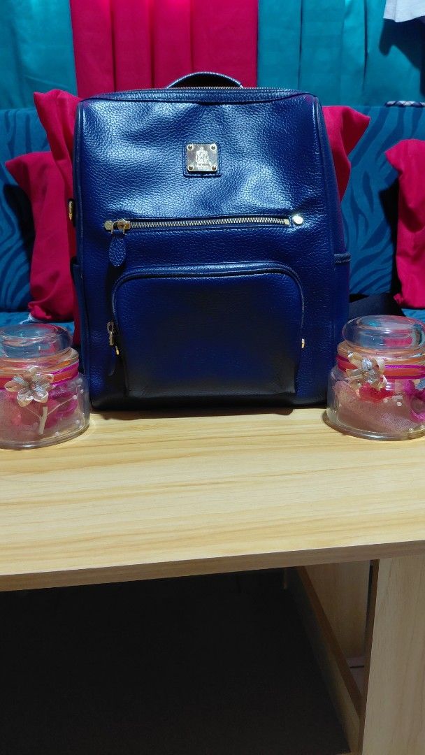 St. Scott London Blue Leather Backpack (Category: Backpacks) located in Davao. Submitted by floresjayne0124 (Listing ID 1468939768, Image 1). Description: - Brand: St. Scott London - Material: Blue pebbled leather with gold hardware - Interior: Pink patterned fabric lining with multiple compartments - Pockets: Front zipper pocket and side pocket flap - Straps: Adjustable black straps with branded lettering plus top handle - Condition: Clean insid