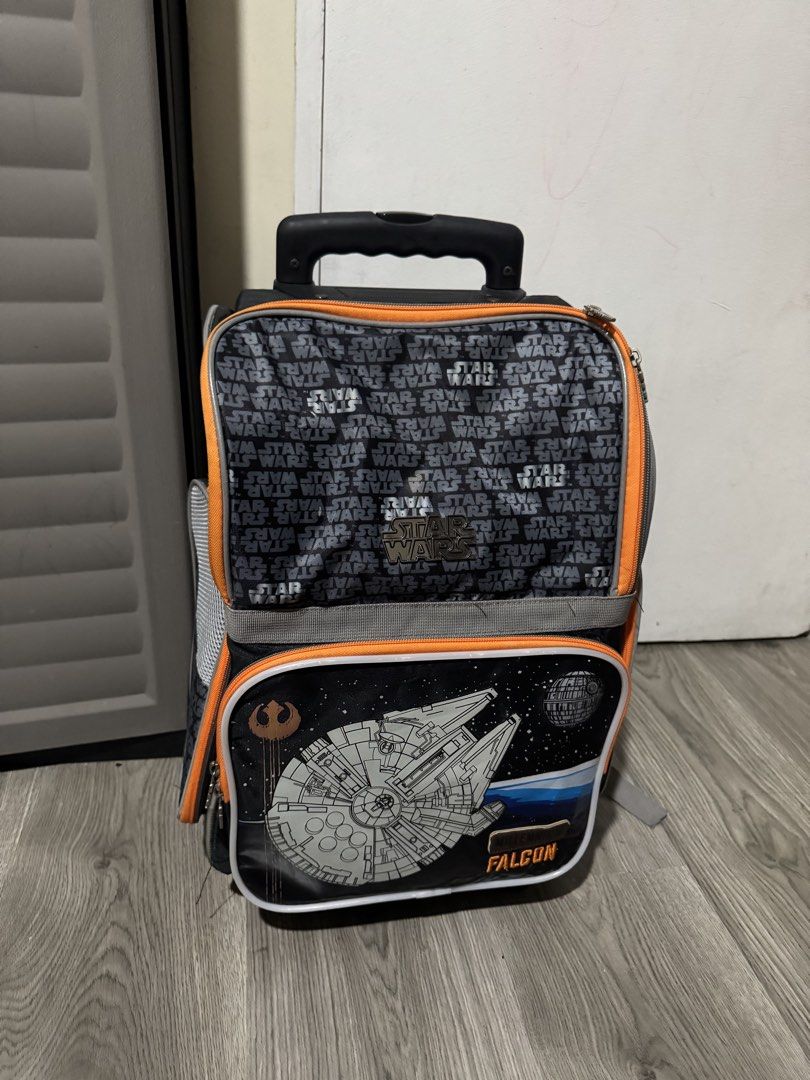Star Wars Millennium Falcon Rolling School Bag (Category: Backpacks) located in Manila. Submitted by iwhanamineonlineshop (Listing ID 1469156367, Image 1). Description: - Official Star Wars Millennium Falcon rolling school bag - Eye-catching front pocket graphic with Death Star and blue space background - Stylish top flap featuring a repeating Star Wars text pattern - Vibrant orange zipper trim and sturdy top grab handle - Equipped with smooth-ro