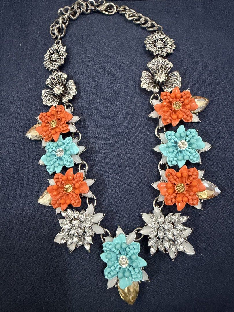 Statement Floral Rhinestone Bib Necklace (Category: Necklaces) located in Makati City. Submitted by petite_preloved2 (Listing ID 1469050800, Image 1). Description: - No missing stones - Eye-catching floral bib necklace with orange, turquoise, and white enamel flowers - Accented with sparkling rhinestone silver flowers and intricate filigree charms - Features a trendy chunky chain link at the top - Adds a vibrant pop of color to plain tops and dre