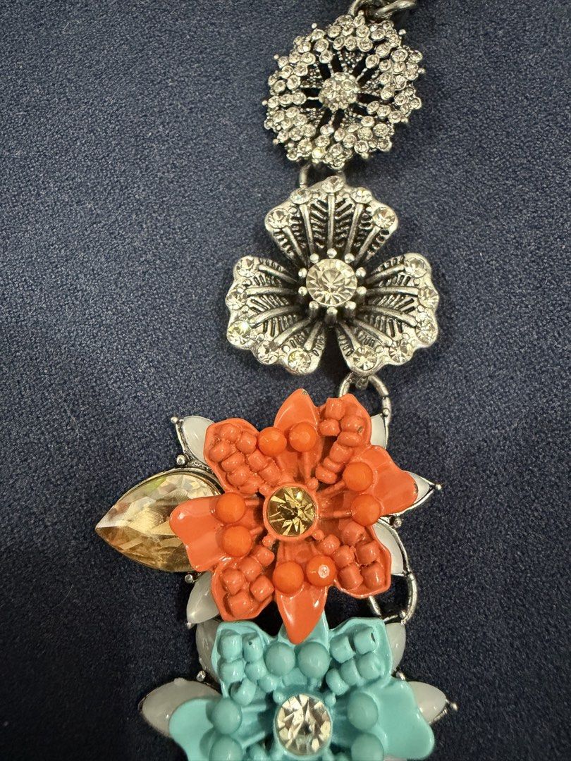 Statement Floral Rhinestone Bib Necklace (Category: Necklaces) located in Makati City. Submitted by petite_preloved2 (Listing ID 1469050800, Image 2). Description: - No missing stones - Eye-catching floral bib necklace with orange, turquoise, and white enamel flowers - Accented with sparkling rhinestone silver flowers and intricate filigree charms - Features a trendy chunky chain link at the top - Adds a vibrant pop of color to plain tops and dre