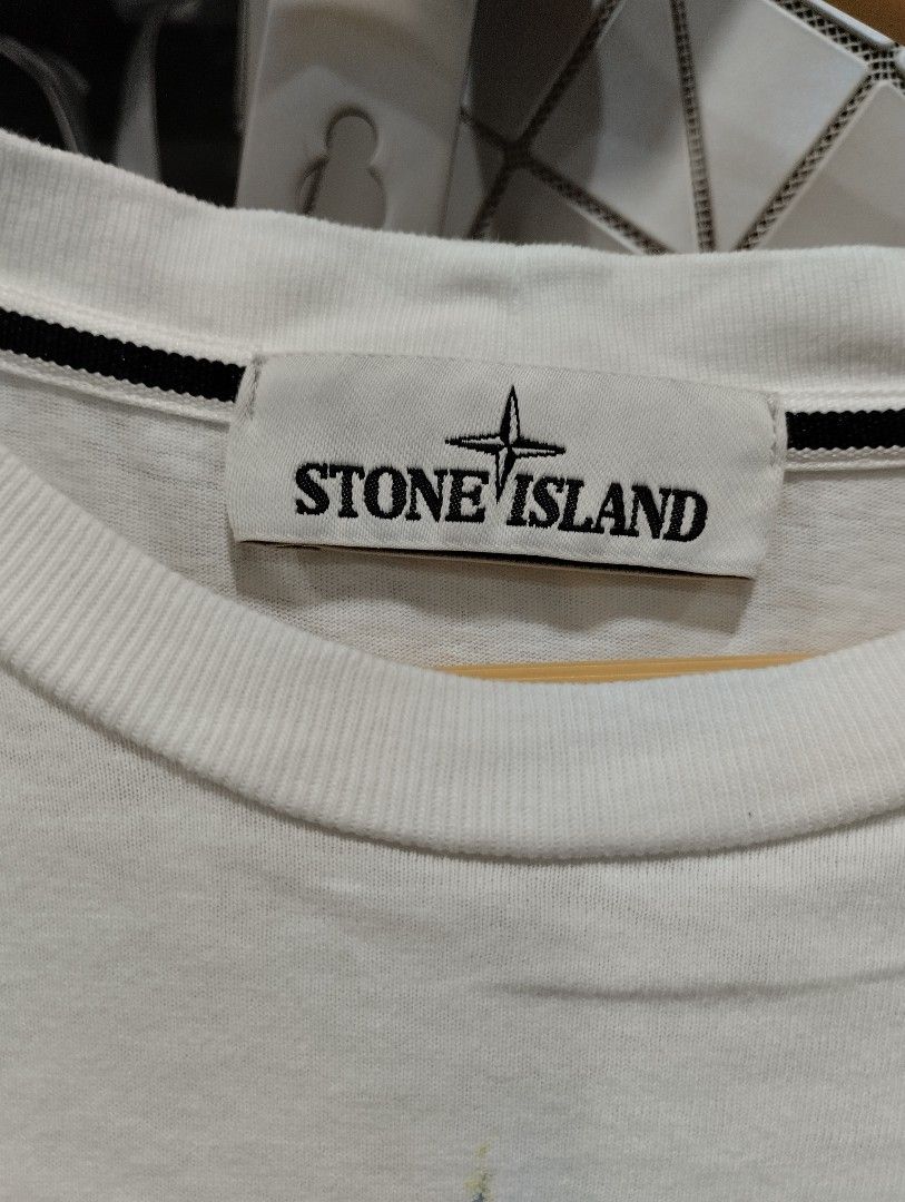 Stone Island White Compass Graphic T-Shirt Size S (Category: Tshirts & Polo Shirts ) located in Manila. Submitted by niggzreyno51476 (Listing ID 1469082012, Image 2). Description: - Brand: Stone Island - Color: White - Size: Men's Small - Design: Large compass graphic print with yellow and grey distressing details on the front - Details: Classic crew neck with black interior striped taping and straight hem - Material: Clean, comfortable cotton fa