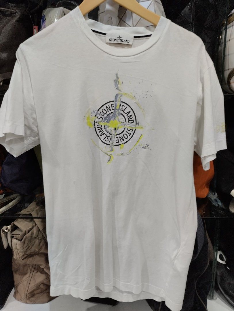 Stone Island White Compass Graphic T-Shirt Size S (Category: Tshirts & Polo Shirts ) located in Manila. Submitted by niggzreyno51476 (Listing ID 1469082012, Image 1). Description: - Brand: Stone Island - Color: White - Size: Men's Small - Design: Large compass graphic print with yellow and grey distressing details on the front - Details: Classic crew neck with black interior striped taping and straight hem - Material: Clean, comfortable cotton fa