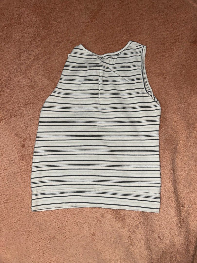 Striped sleeveless tank top with diagonal pattern (Category: Sleeveless) located in Manila. Submitted by prelovedbyanavi (Listing ID 1468954553, Image 2). Description: - Color: White and dark grey - Design: Intersecting diagonal stripes on the front, horizontal stripes on the back - Neckline: Scoop neck - Fit: Relaxed, lightweight material ideal for warm days - Details: Thick ribbing at the bottom hem - Condition: Excellent (ready to wear).