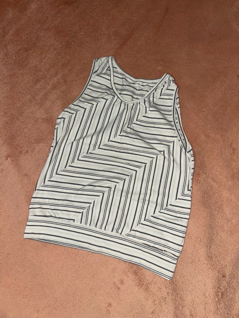 Striped sleeveless tank top with diagonal pattern (Category: Sleeveless) located in Manila. Submitted by prelovedbyanavi (Listing ID 1468954553, Image 1). Description: - Color: White and dark grey - Design: Intersecting diagonal stripes on the front, horizontal stripes on the back - Neckline: Scoop neck - Fit: Relaxed, lightweight material ideal for warm days - Details: Thick ribbing at the bottom hem - Condition: Excellent (ready to wear).