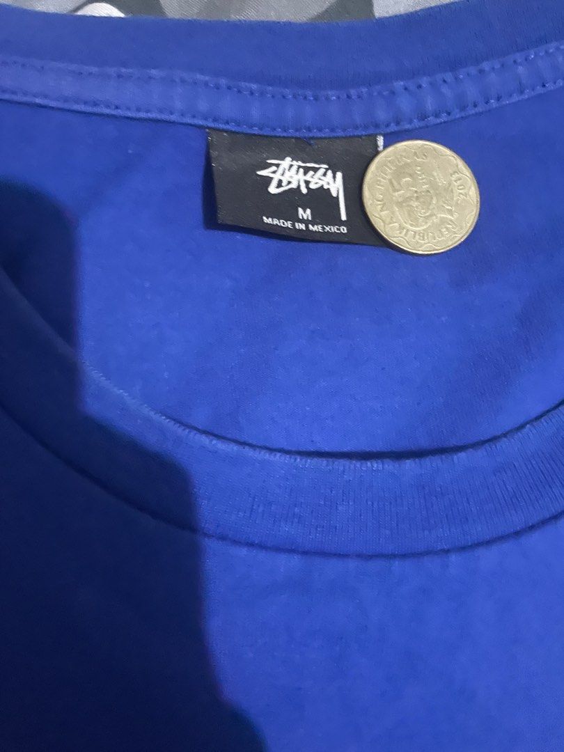 Stüssy Blue T-Shirt Size M (Category: Tshirts & Polo Shirts ) located in Manila. Submitted by yojthrifted (Listing ID 1469088431, Image 3). Description: - Brand: Stüssy - Color: Blue with white signature graphic print (chest and back) - Size: Medium (Standard Fit) - Material: 100% Cotton - Origin: Made in Mexico - Condition: Excellent streetwear basic - Shipping or meetups available across the Philippines .